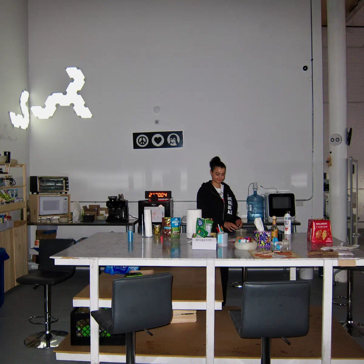 A person standing beside the kitchen table in the 2389 Research office.
